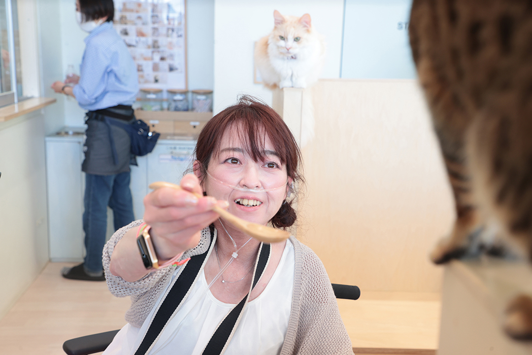 猫のおやつあげに挑戦している中田さんの写真