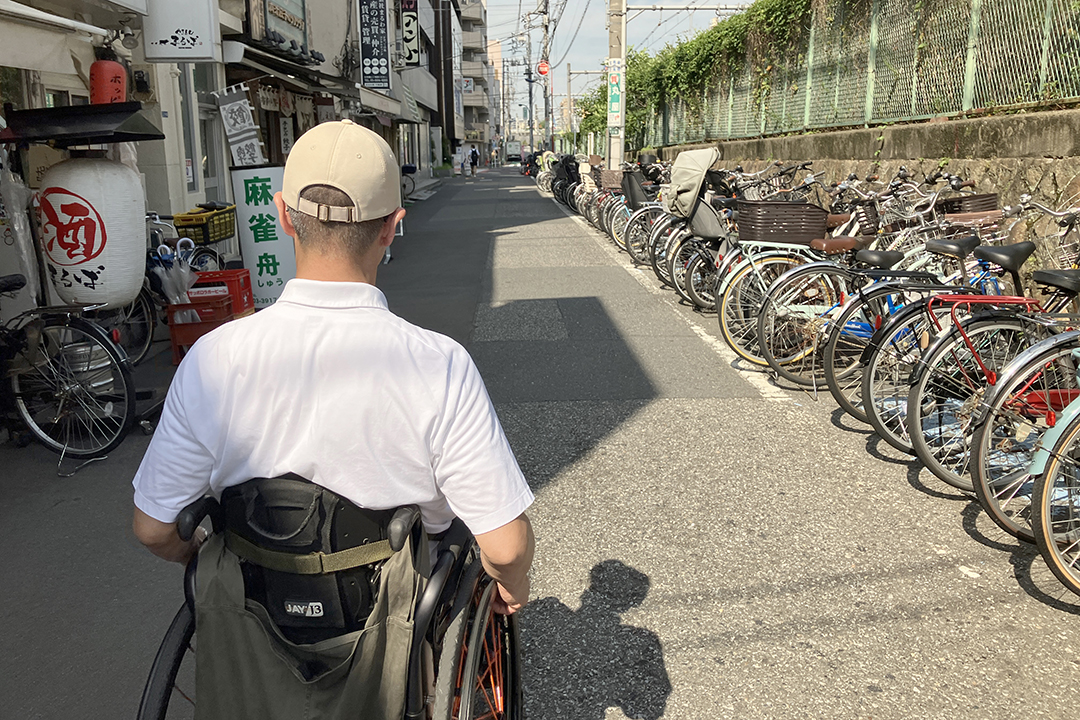 筆者（車いす）が東口を出て道路を右方向に進んでいる写真