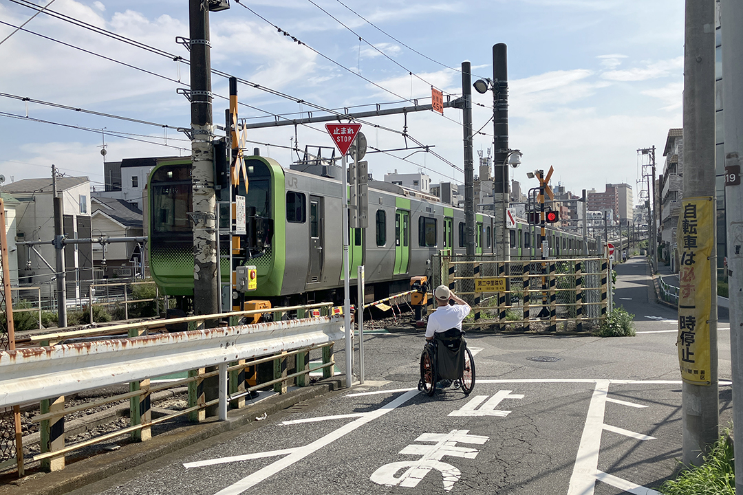 第二中里踏切で電車が通過するところを写している筆者の写真