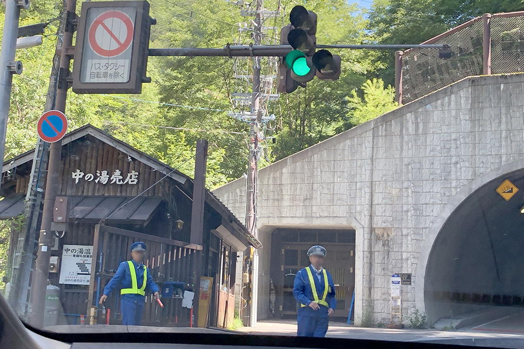 釜トンネル入口の前に立っている警備員二人の写真