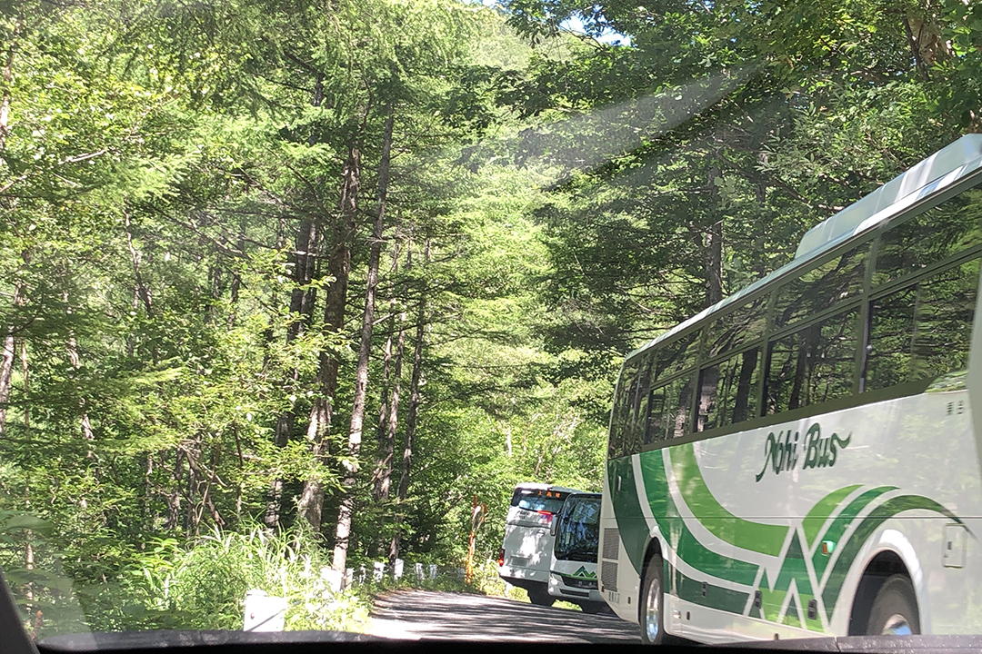 狭い道路で観光バスのすれ違いを写した写真