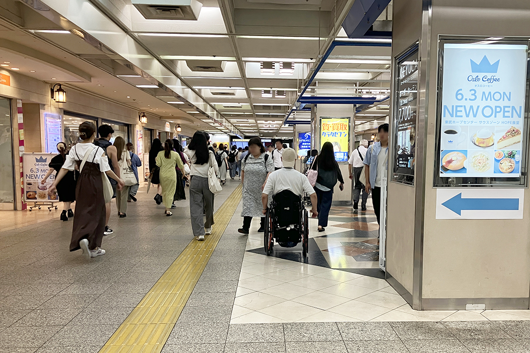 そのまま通路を進む車いすの筆者の写真