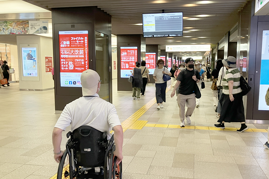 駅構内を改札に向かって進む車いすの筆者