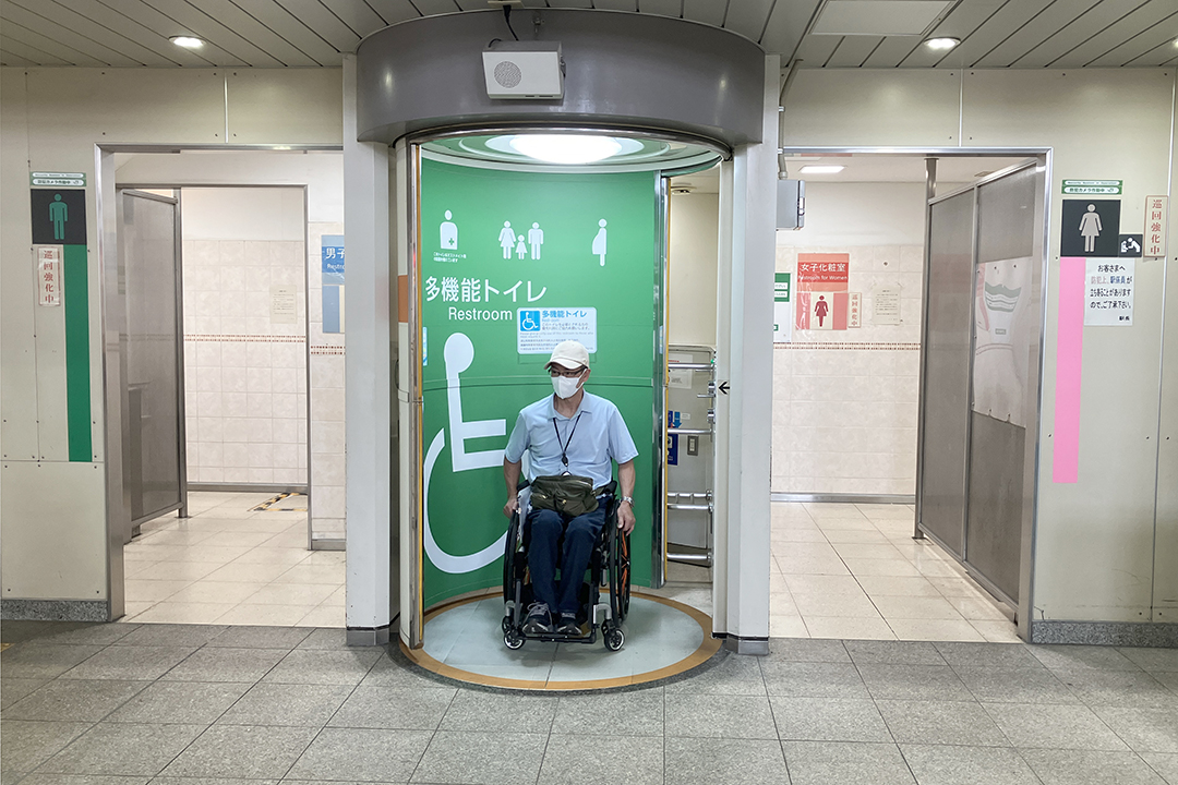 車いすの筆者が車いす用トイレに入ろうとしている写真