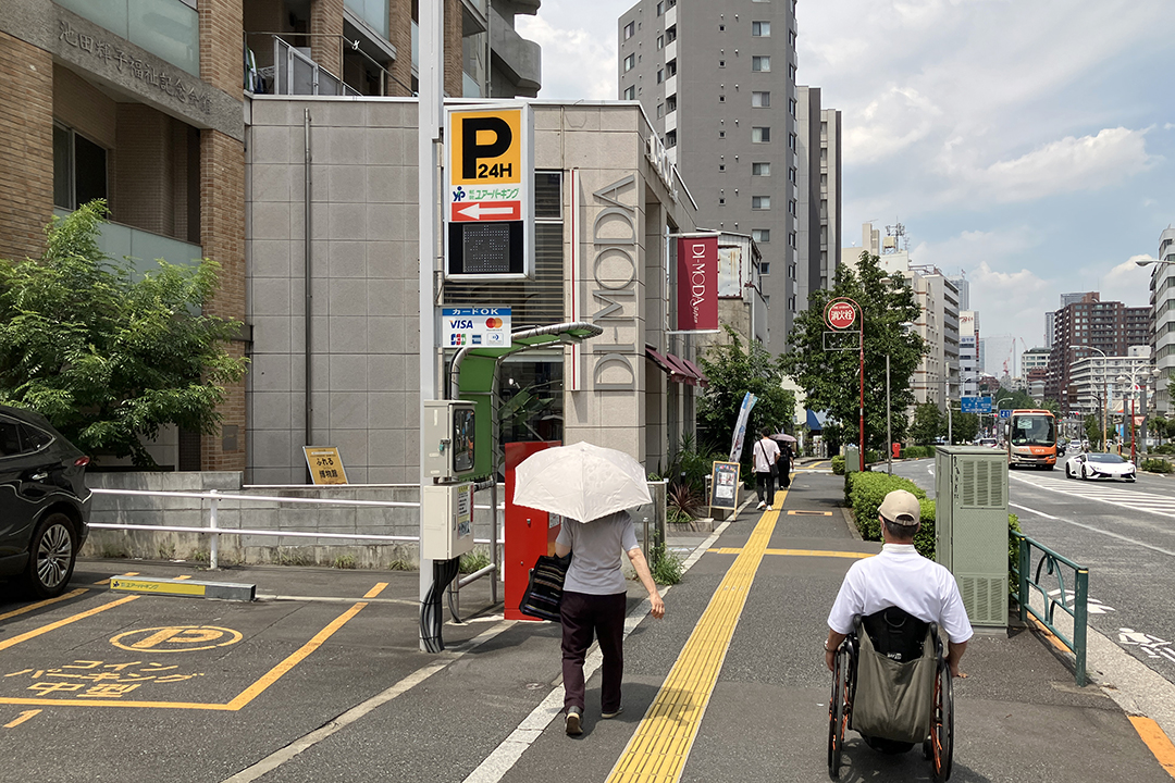 コインパーキングの先にあるビルを筆者が見ている写真