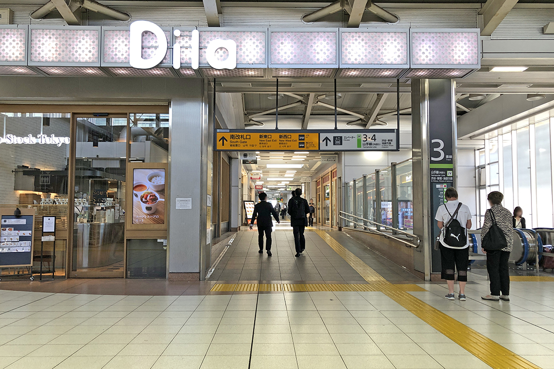 Dila大崎の通路の入口と南改札口への案内板(オレンジ色)の写真