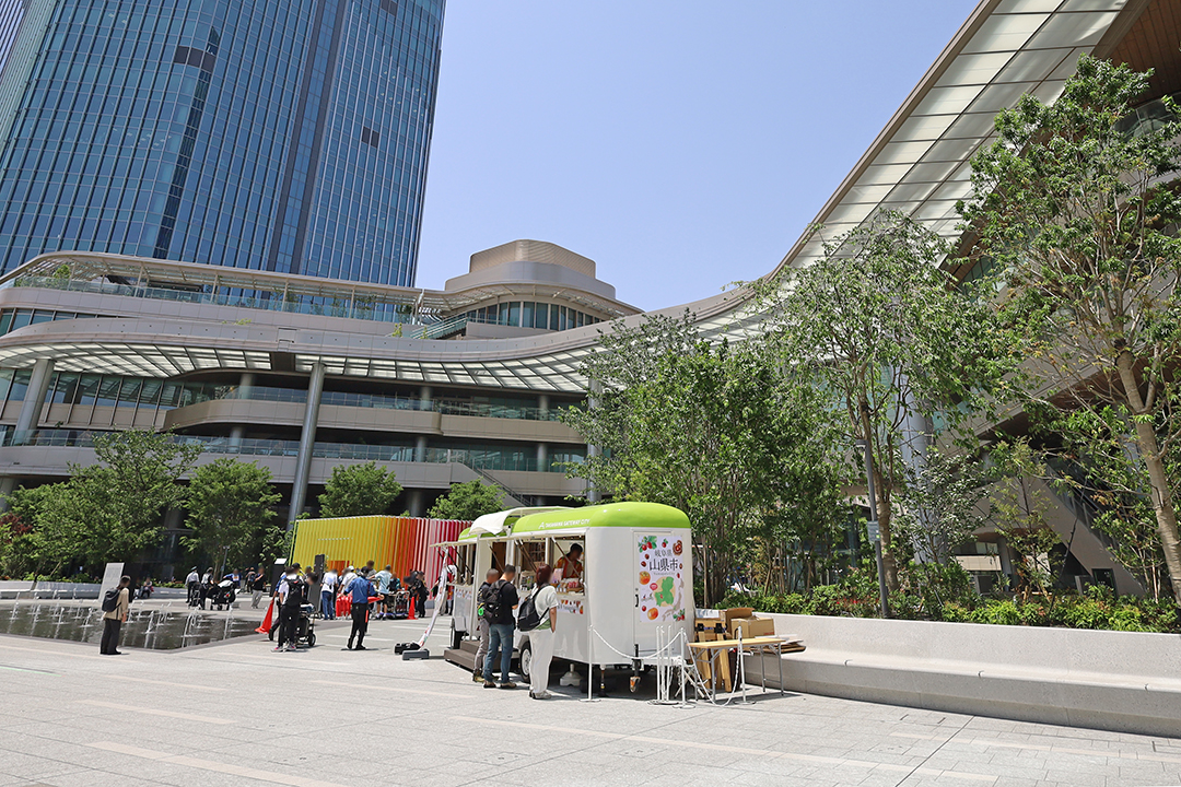駅前広場の正面にフードトラックなどが展開されていて人々がお昼ご飯を買い求めている