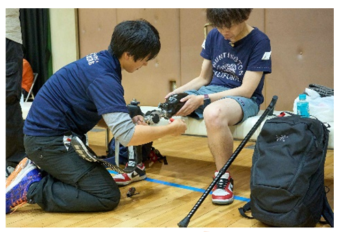 体育館内で義足を装着してもらっている男性の様子