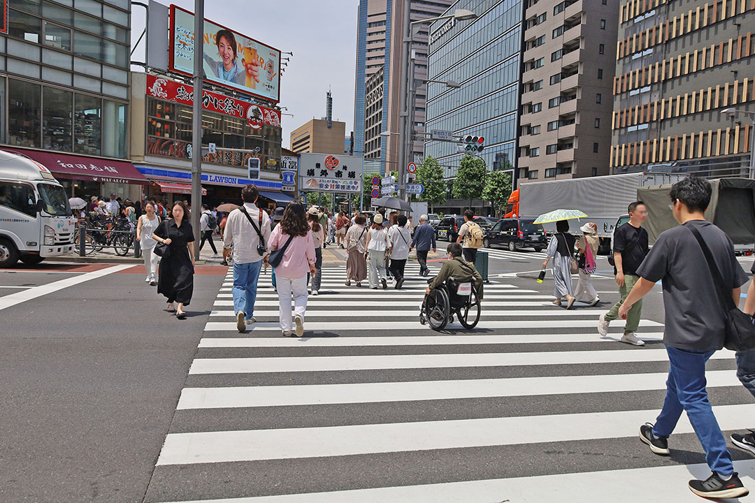 ビジネスマンや観光客、買い物客の人々が横断歩道を行き交い、活気がありにぎやかです。