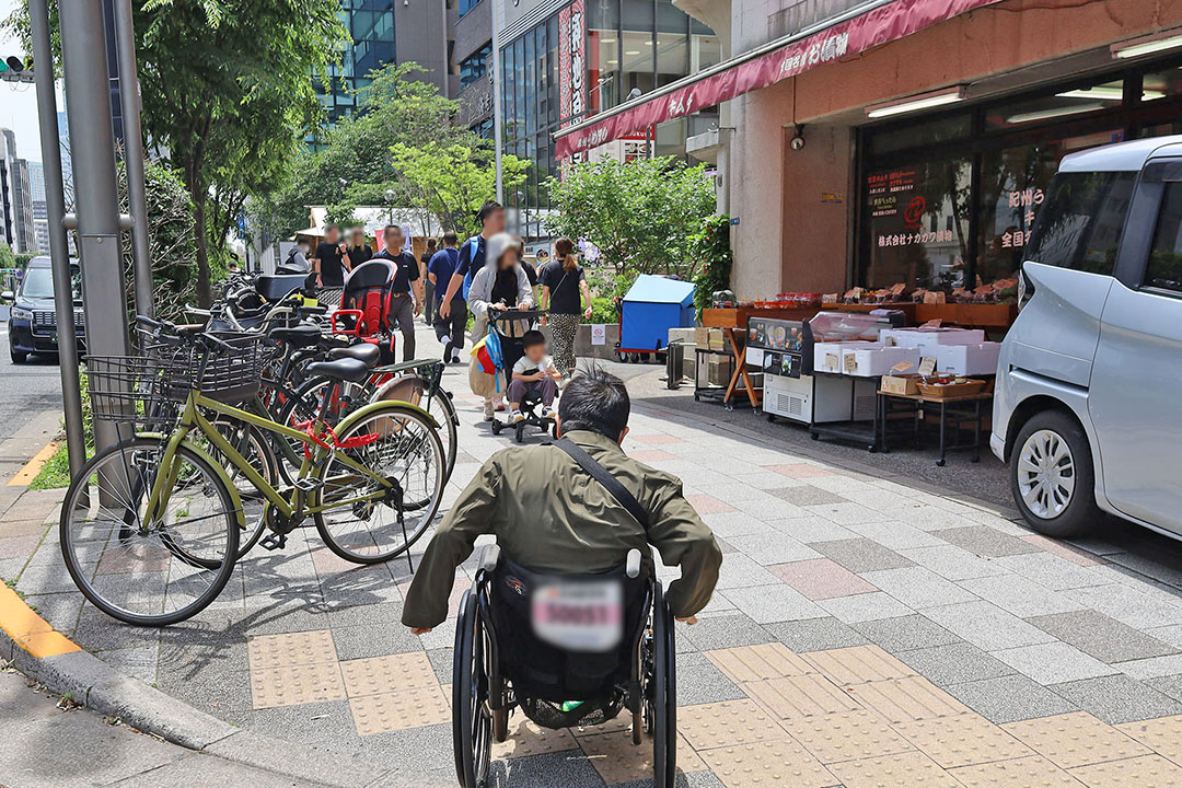 親子連れや買い物客など様々な人々が行き交い、日常の穏やかさと賑わいが共存し、親しみやすい雰囲気です。