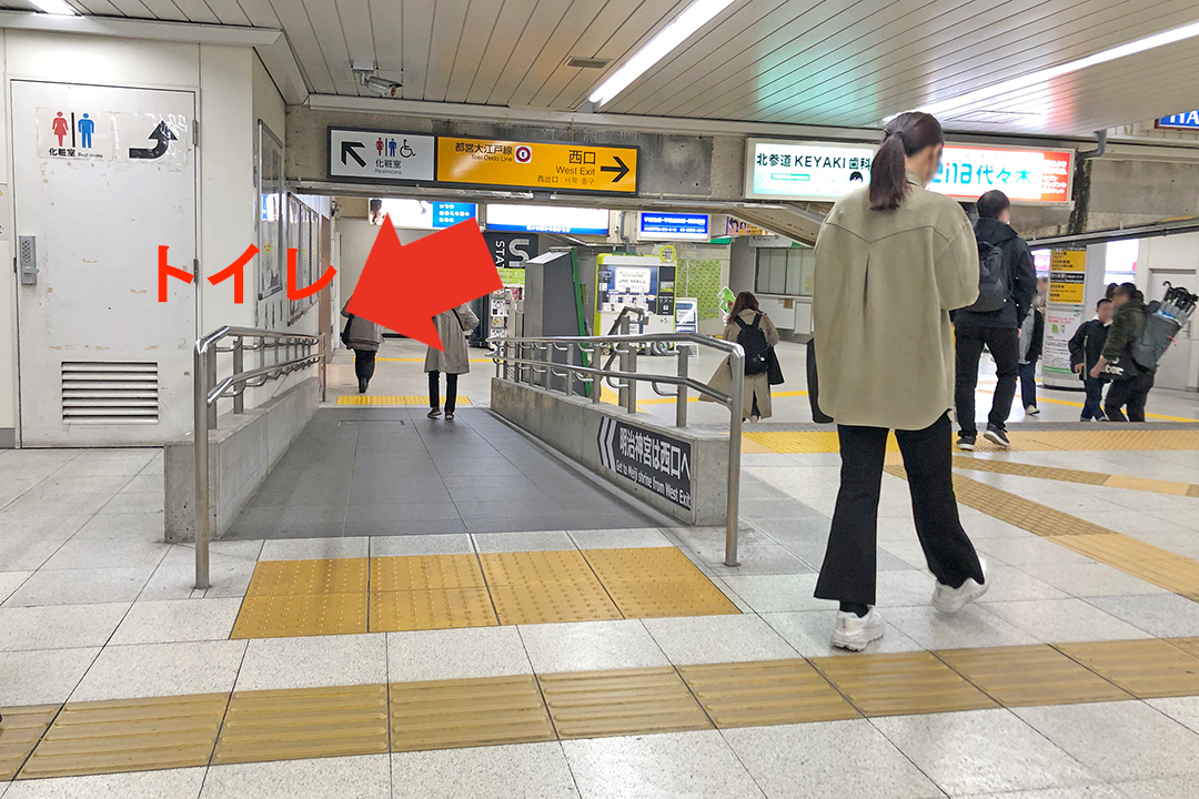 西口改札前のトイレの位置を矢印で示した写真