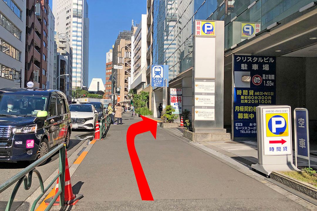 西口改札から大江戸線へ向かうルートを矢印で示した写真　エレベーターが先に見える