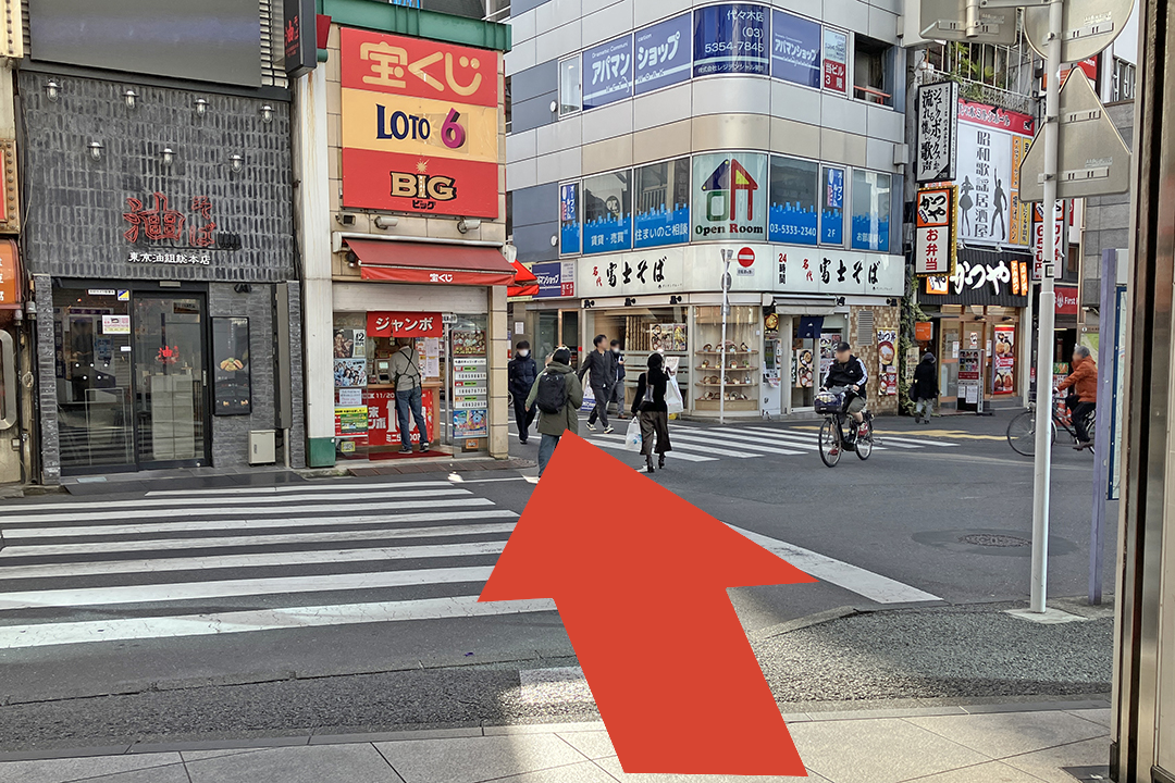 西口改札からアジアンスタンドアマへ行くルートを矢印で説明した写真　宝くじの看板の右側の路地に入る