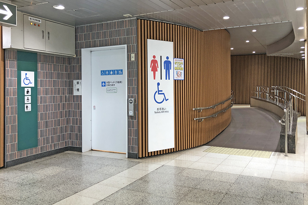 通路の突き当り右側にあるトイレ。白いドアが車いす用トイレ