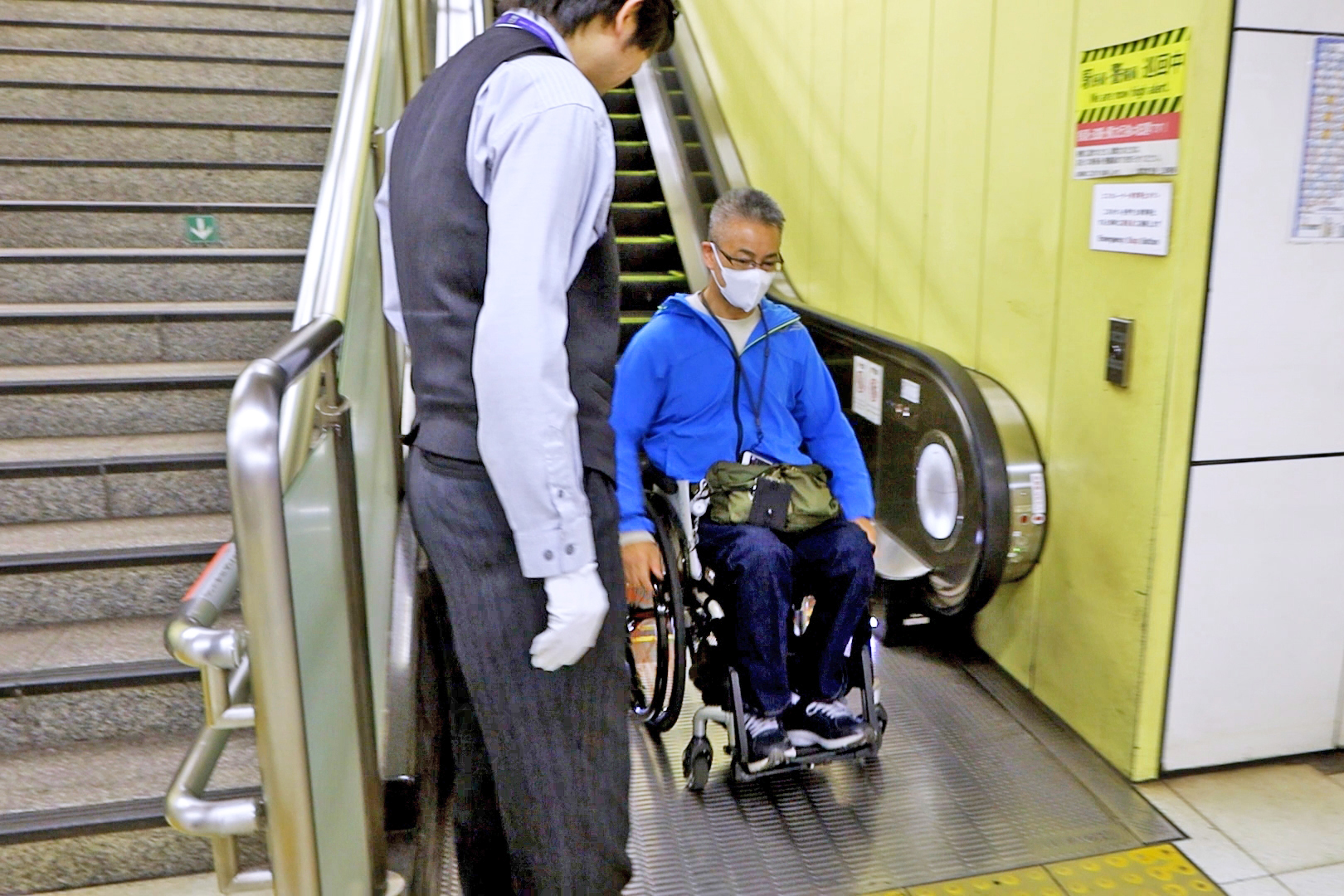 駅員に誘導されながら下りエスカレーターから降りる筆者
