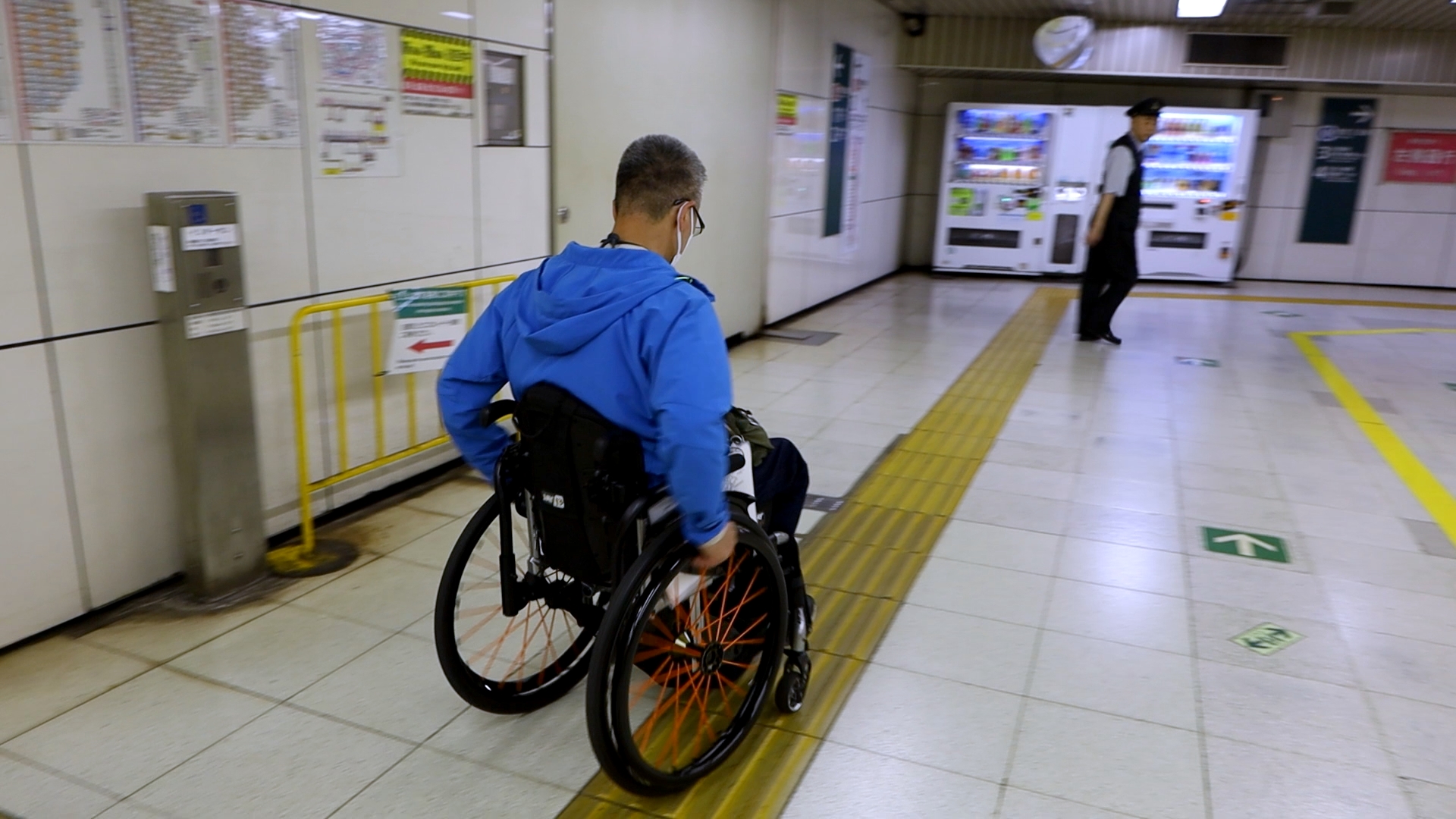 エスカレーター降りて通路を進む筆者