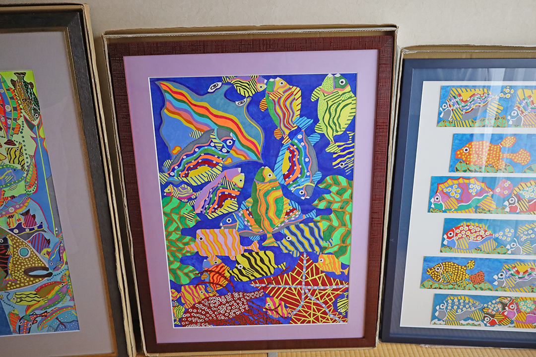 小幡さんの描いた絵が並んでいる。海の中にカラフルな色彩で魚やヒトデ、エビ、海藻などが描かれている。