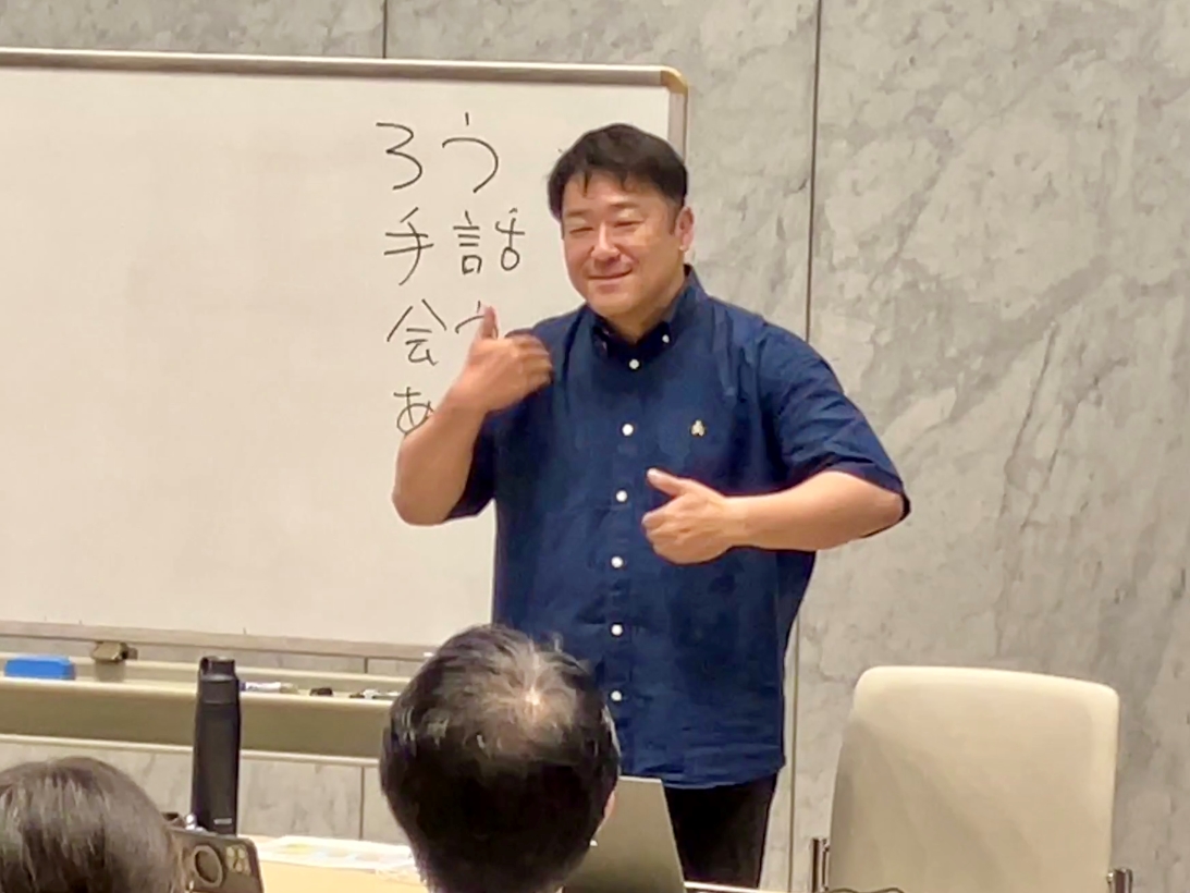 ありがとうの手話　胸の前で手の甲を相手に向け、右が上左が下から、上下に動かす