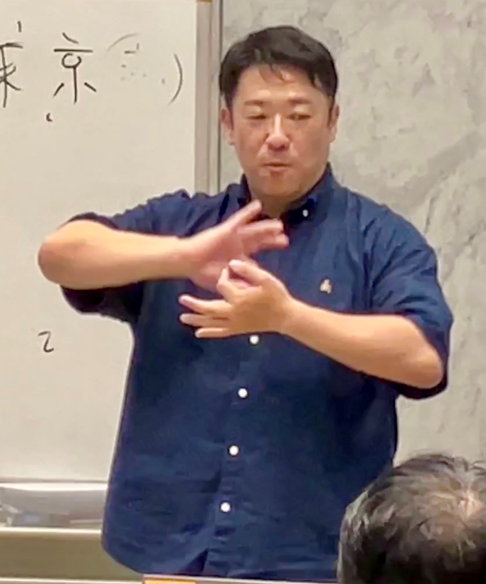 デフリンピック１　親指と人差し指で丸を作って胸の前で重ね