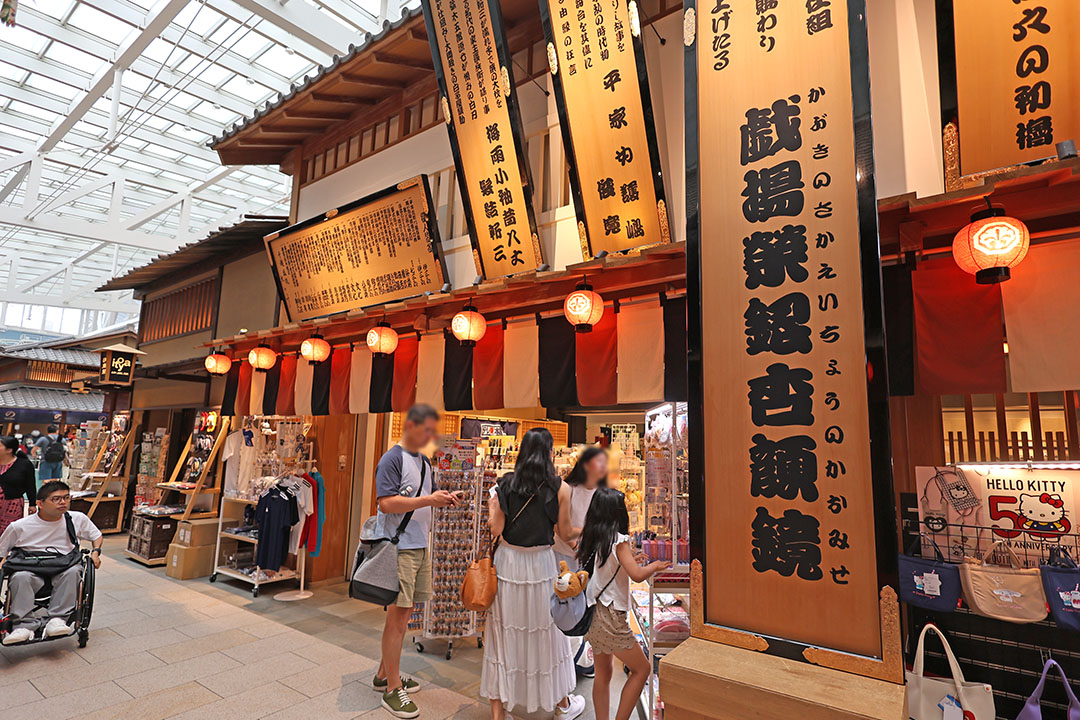 大きな木製の看板や提灯、伝統的な建物のデザインが、家族連れや観光客で買い物や散策を楽しんでいます。