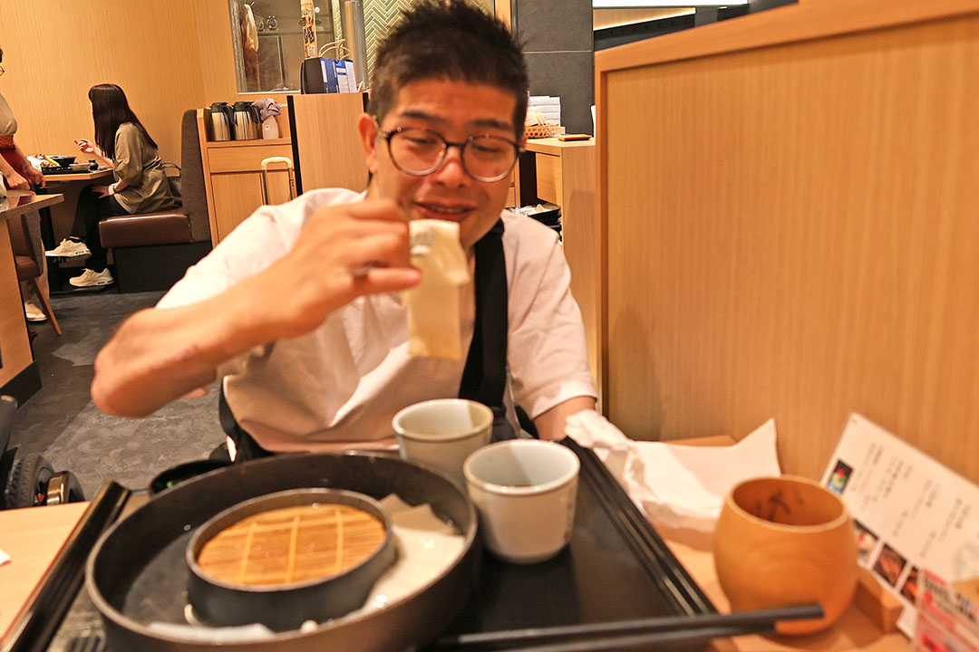 幅の広いうどんを美味しそうに食べている様子です。