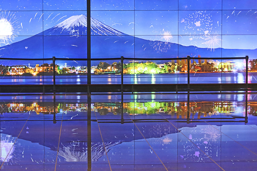 大きなディスプレイに映し出された富士山や夜空に打ち上がる花火、湖畔の街明かりが美しく輝いています。