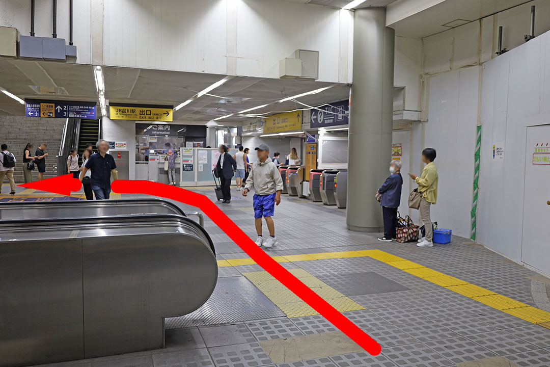 手前左側に１番線ホームに上がるエスカレーター。その先の右側が改札で左側が２番線ホームに上がる階段とエスカレーターがあり、その左側にエレベーターに乗れる通路