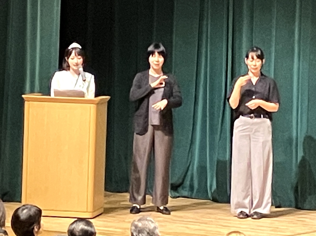 講壇の日本手話と国際手話の通訳者