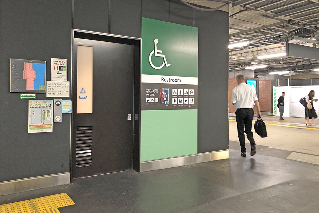 C・Bエレベーター前の通路に位置するトイレの入口（緑色看板の左側が車いす用）