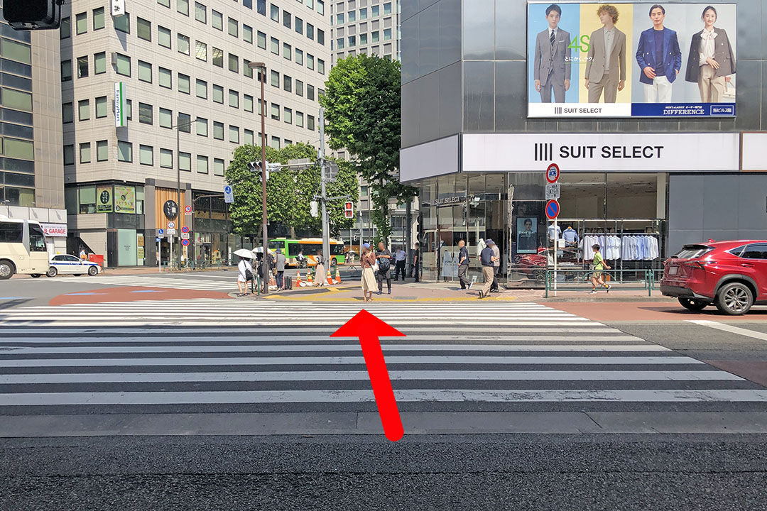 横断歩道とビルの左側の歩道が見える写真。