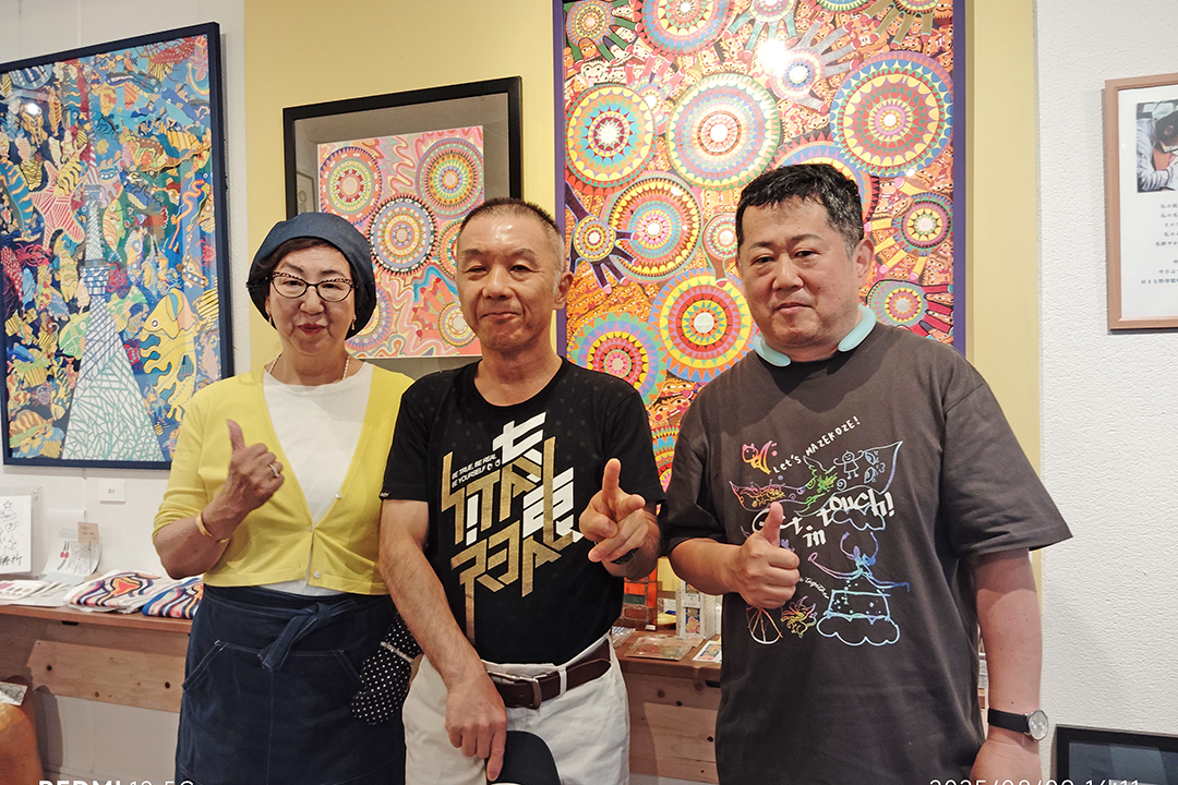 作品を背に左から代表理事の大石さん、小幡さん、筆者の小川