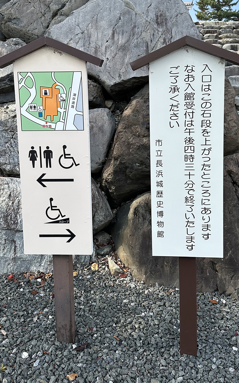 トイレが左に、スロープが右にあるという案内図。入口が正面の石段を上がった先にあり、入館受付が午後4時30分終了という注意書きもある