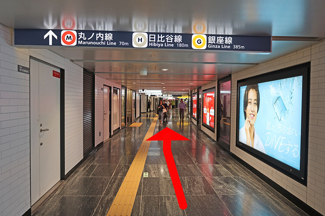直進方向に丸ノ内線の案内板がある通路の写真