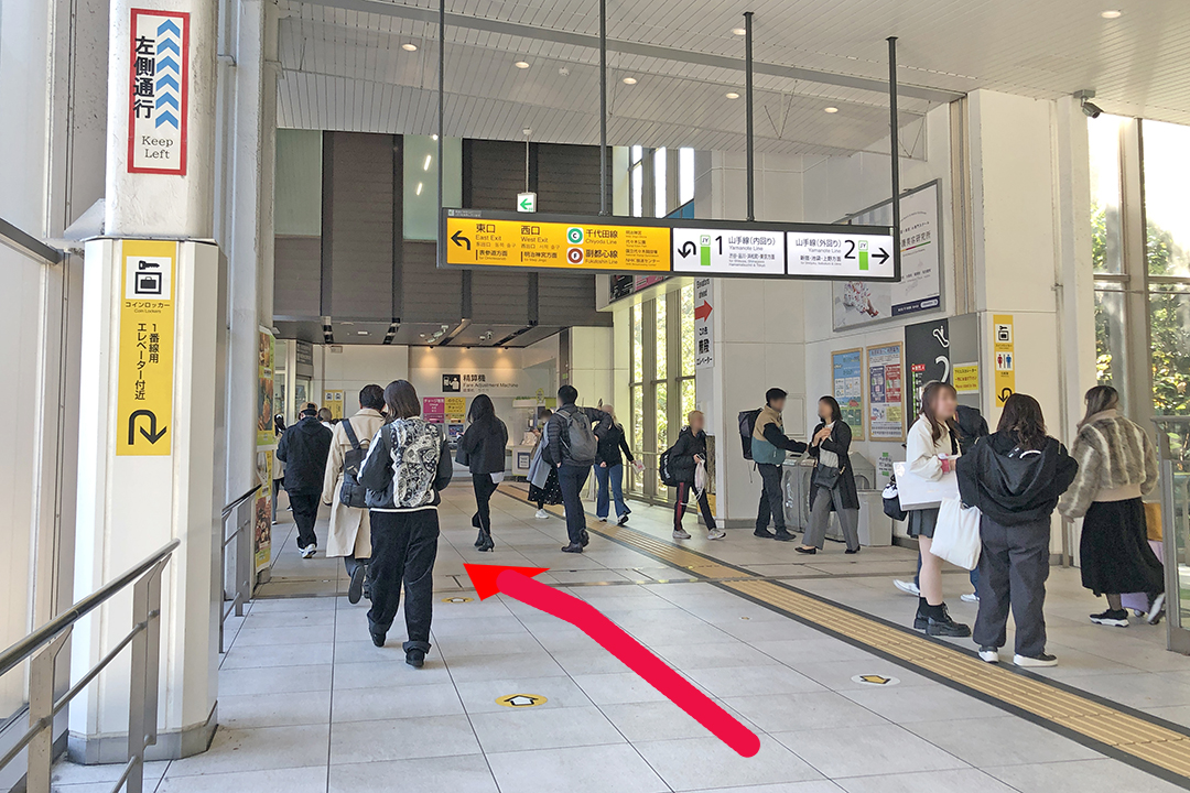通路の先を斜め左方向に改札が見える写真