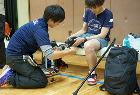 体育館内で義足を装着してもらっている男性の様子