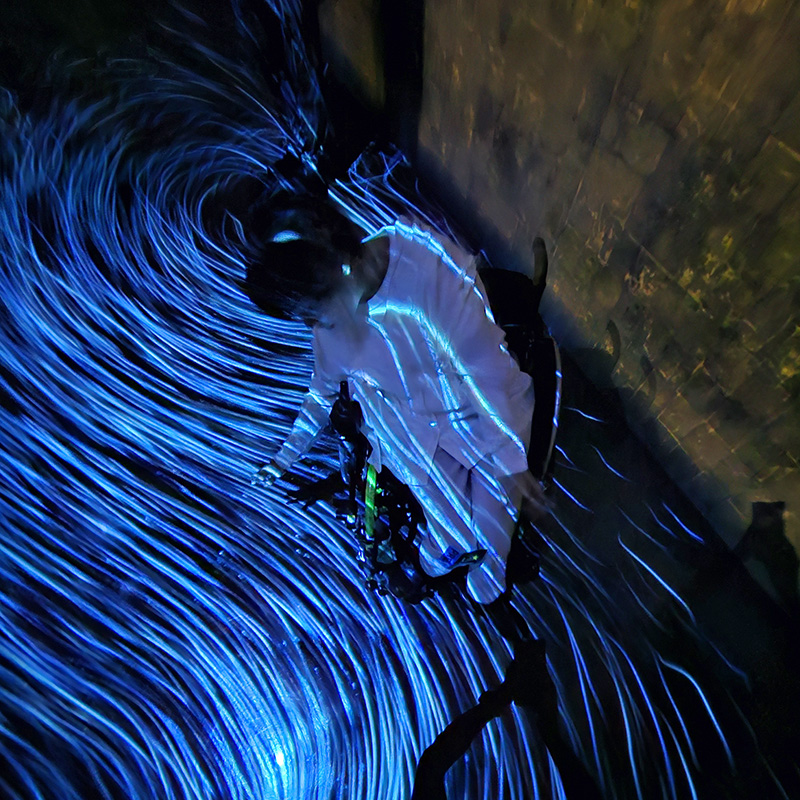 光の渦や流れの中で戯れている車いすの女性