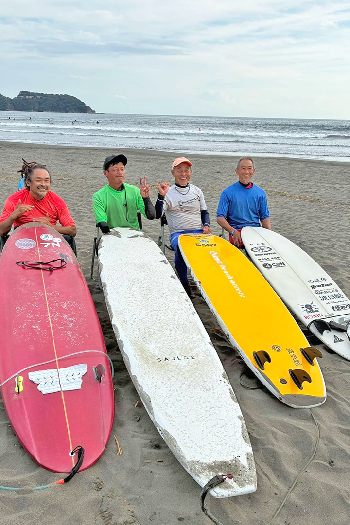 4人のパラサーファーが海をバックに並んでいます。