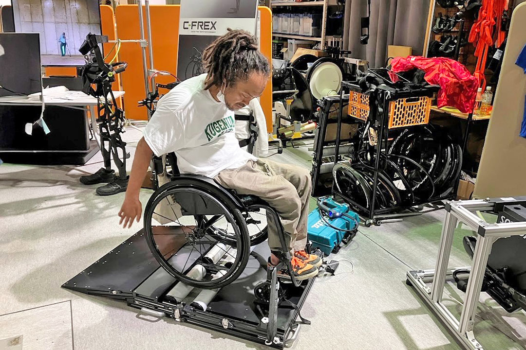 台の上で車いすをこぎ、データ計測中の生方氏