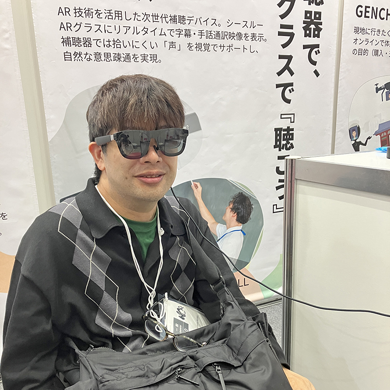 補聴グラスをかけ、体験している男性