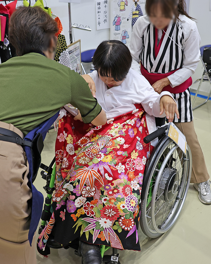 振袖の着付けを体験している車いすの女性1