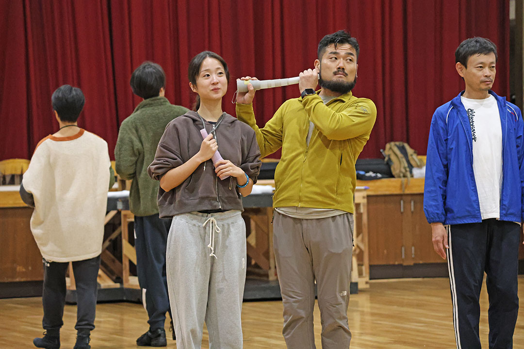 ラッパのような物でおしゃべりをする演技をする役者たち２