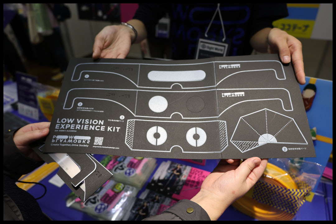 ロービジョン体験キットの台紙　黒い紙に明るい色で眼鏡を広げた形の輪郭線が印刷されている