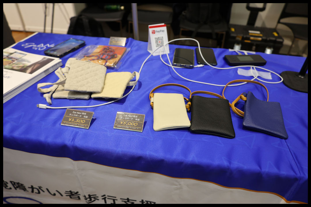 アイナビ専用携帯ネックポーチの展示　キルティング製と革製の2種類があり、革製はアイボリー、黒、紺の3色