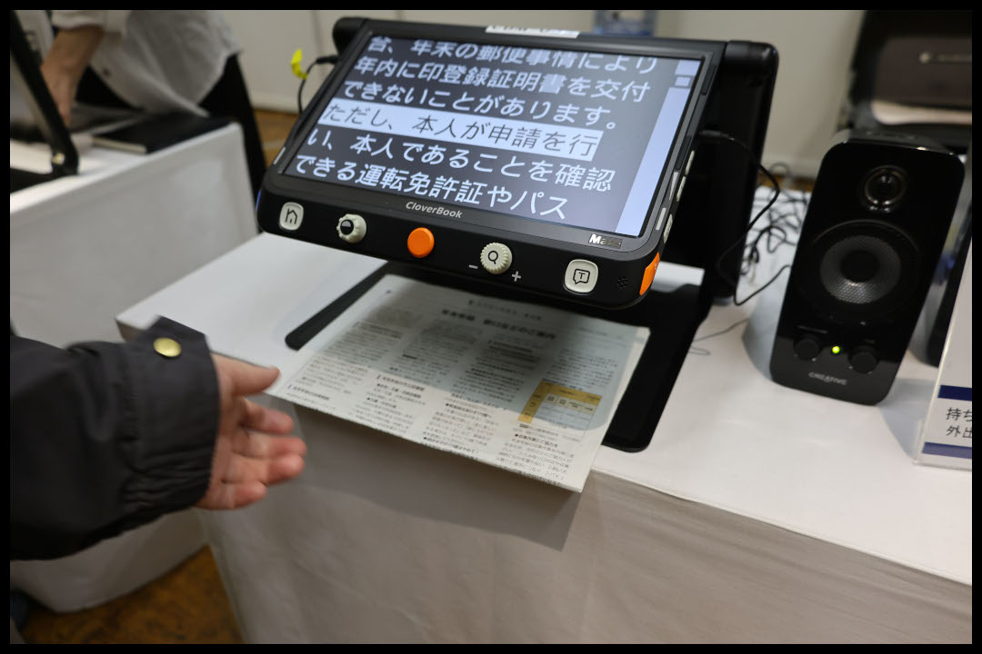 卓上型拡大読書器クローバーブックが、書類の文字を拡大表示している様子