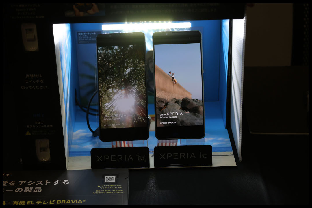 ソニー製のスマホの従来機種と最新機種の比較展示　背後からライトが当たり画面の眩しさを比べることができる