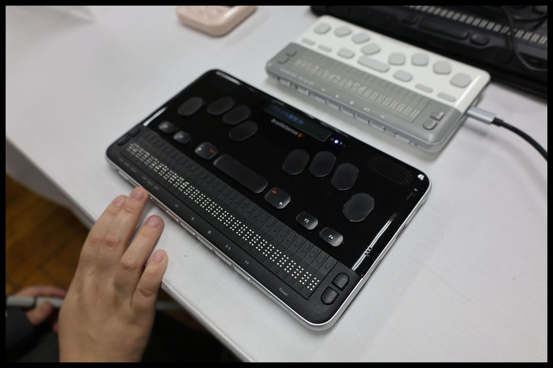 黒い点字ディスプレイのキーボード部分を操作している様子