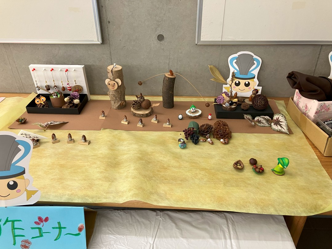 テーブルの上にどんぐりや松ぼっくりで作った工作品が並んでいる