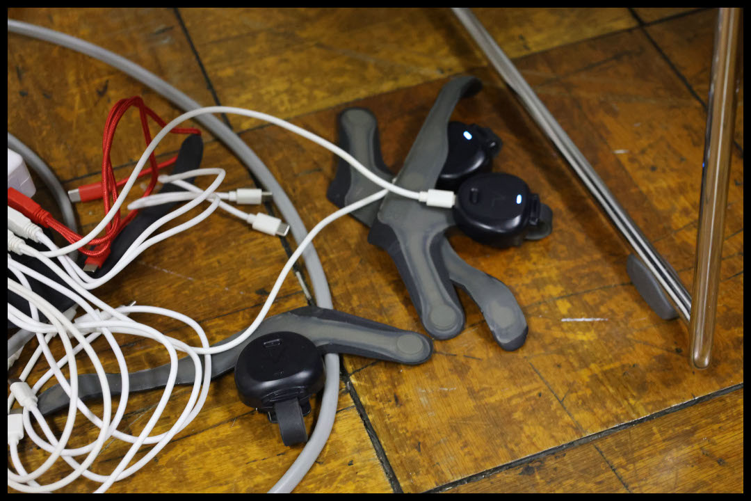 木製の床の上で、充電されている「あしらせ」デバイス