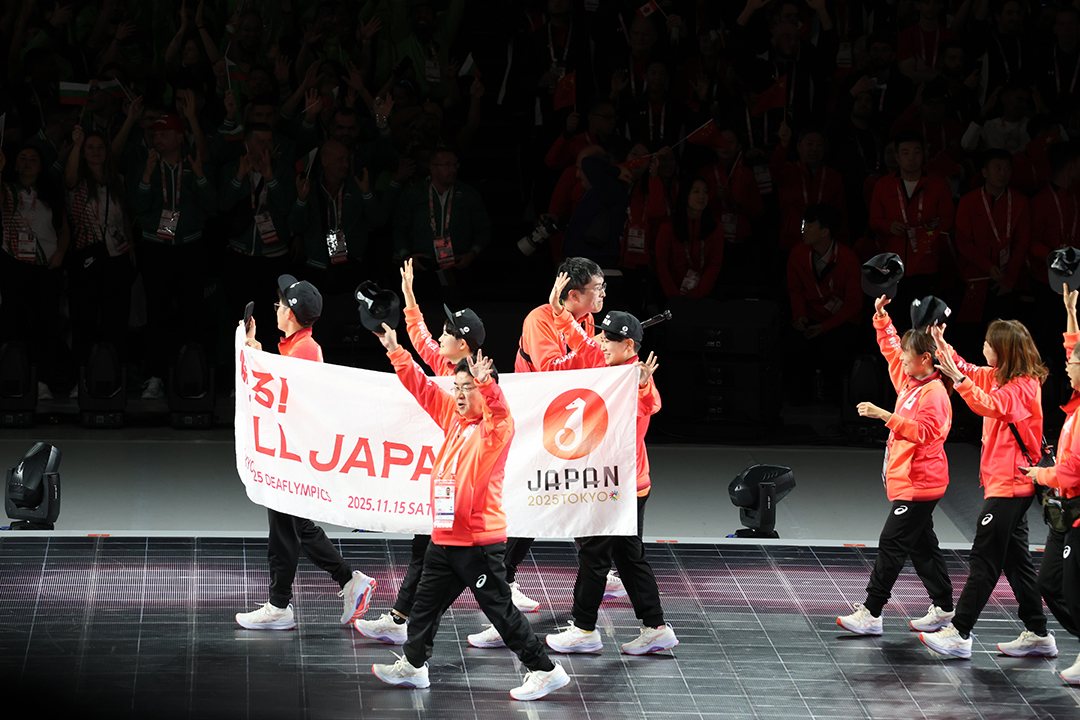 日本選手団、燃えろALL JAPANの旗を3人で持って行進してます
