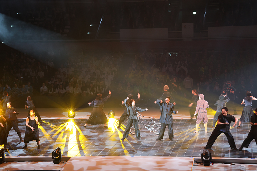 黄色いまぶしい光の中で男女が踊っています